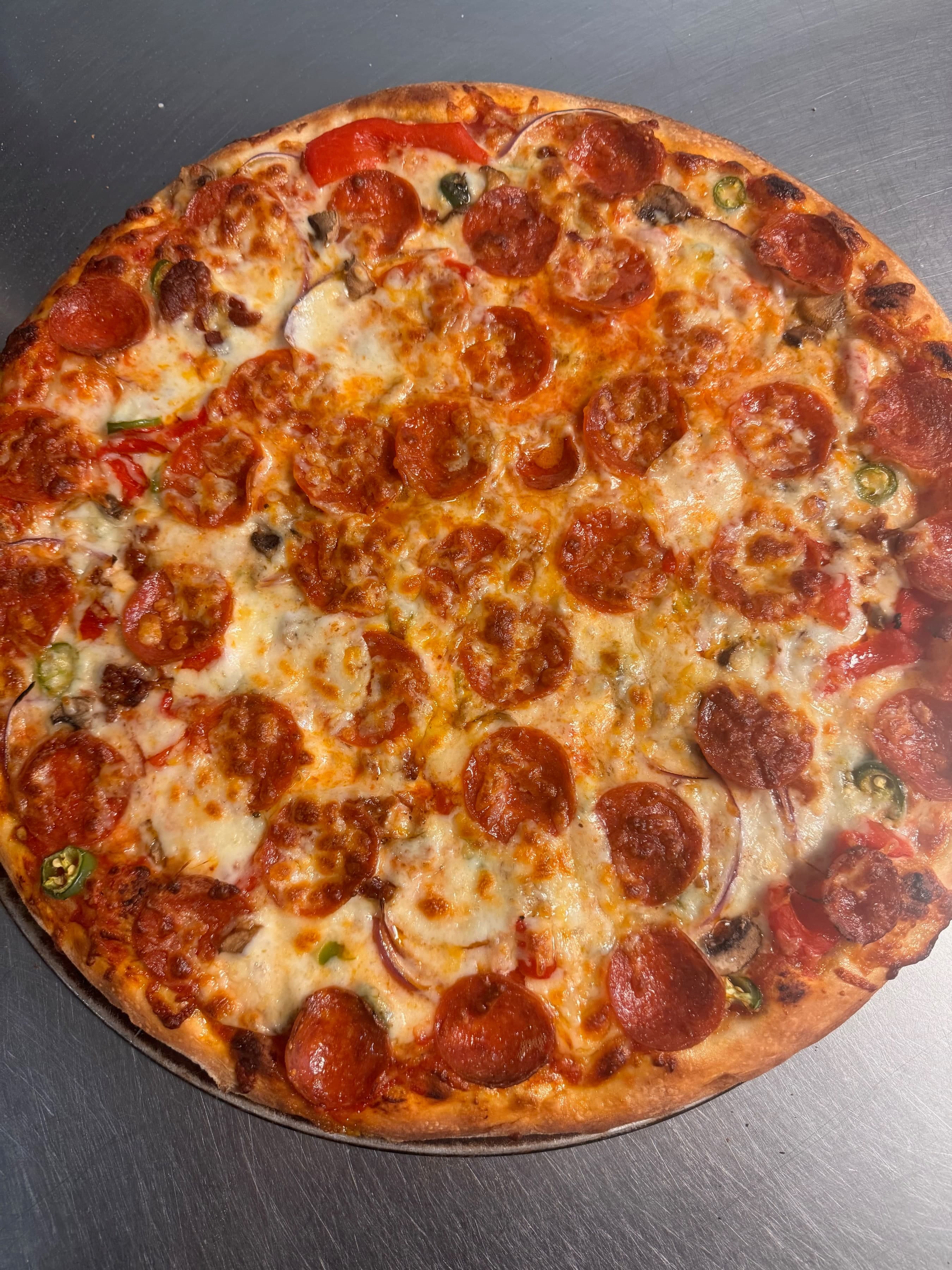 Stone-baked pepperoni and pepper pizza for catering trays.
