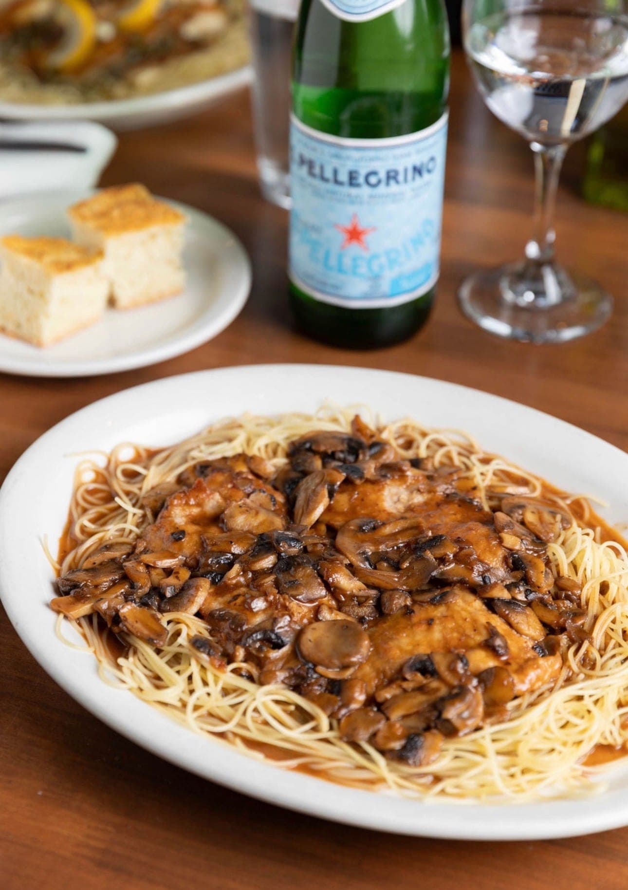 Chicken marsala over angel hair with a bottle of San Pellegrino.